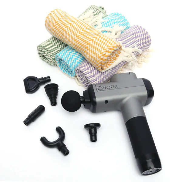 Massage gun with attachments and rolled-up towels on a white background