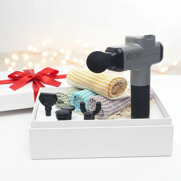 Massage gun with attachments and towels on a white background