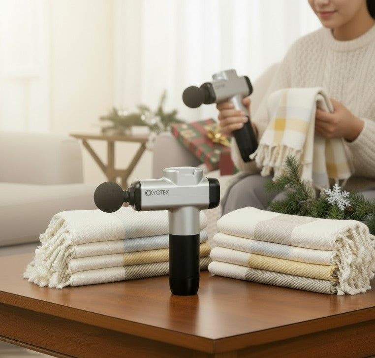 Person using a massage gun with folded towels on a table in a living room setting