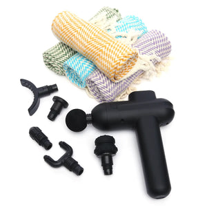 Black massage gun with various attachments and colorful rolled-up Turkish Towels on a white background